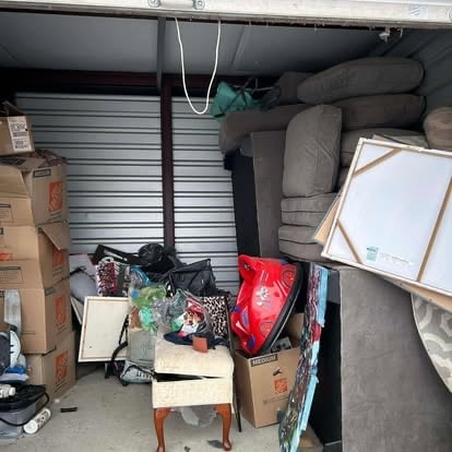 Cluttered storage unit packed with furniture, boxes, and household items before a Mako cleanout